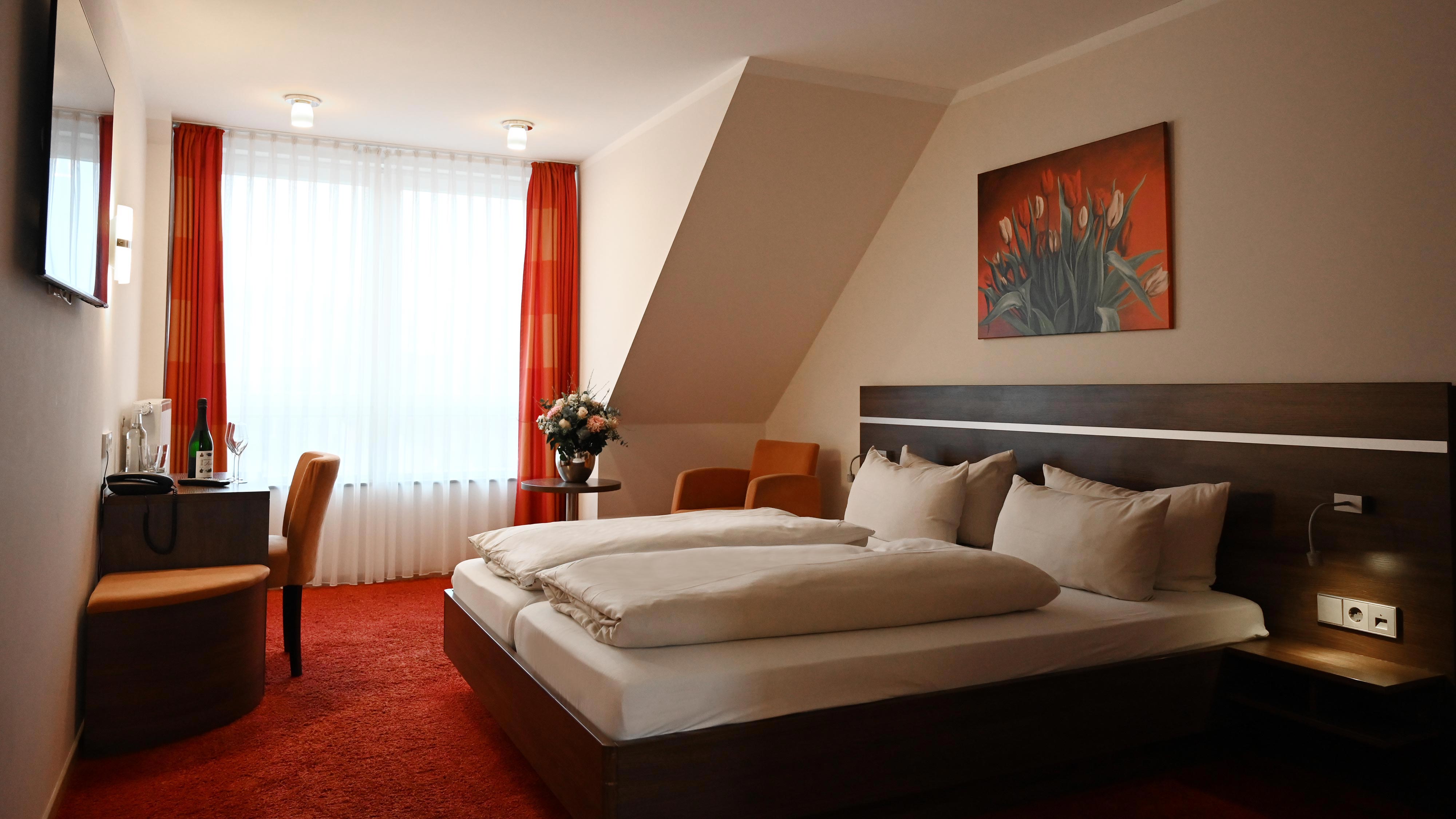 Modernes Hotelzimmer im Hotel Schmidt am Markt in Meppen. Komfortable Ausstattung, zentrale Lage am Marktplatz und ideal für Geschäfts- oder Urlaubsreisen. Jetzt direkt buchen & sparen.